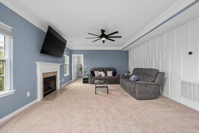 living area featuring light carpet, a high end fireplace, visible vents, and ornamental molding