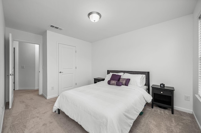 bedroom featuring visible vents, light carpet, and baseboards