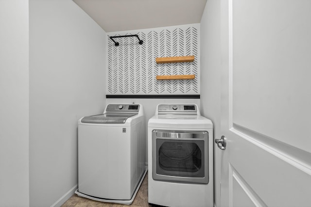 washroom featuring washing machine and dryer, laundry area, and baseboards