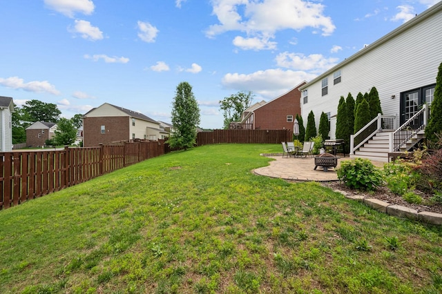 view of yard featuring an outdoor fire pit, a patio area, a fenced backyard, and a residential view