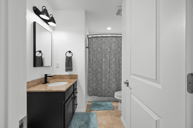 bathroom with toilet, tile patterned floors, and vanity