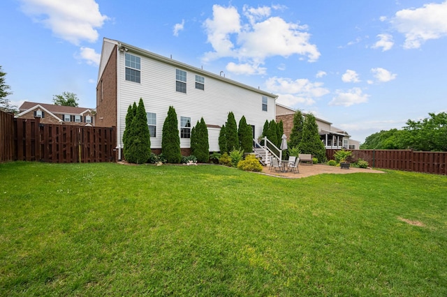 rear view of house with a patio area, a fenced backyard, and a lawn