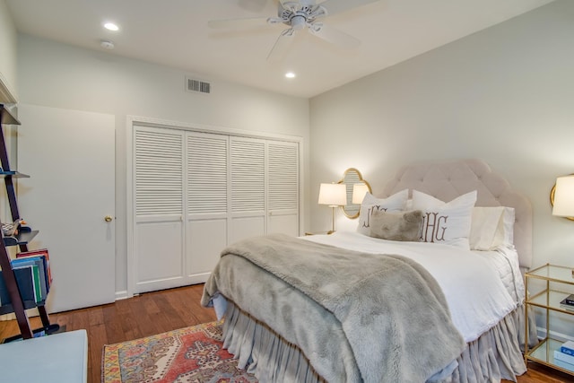 bedroom with a closet, visible vents, wood finished floors, and recessed lighting