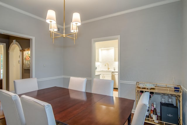 dining room with arched walkways, ornamental molding, and an inviting chandelier