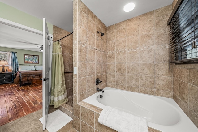 ensuite bathroom featuring a relaxing tiled tub, a tile shower, ensuite bath, and ceiling fan