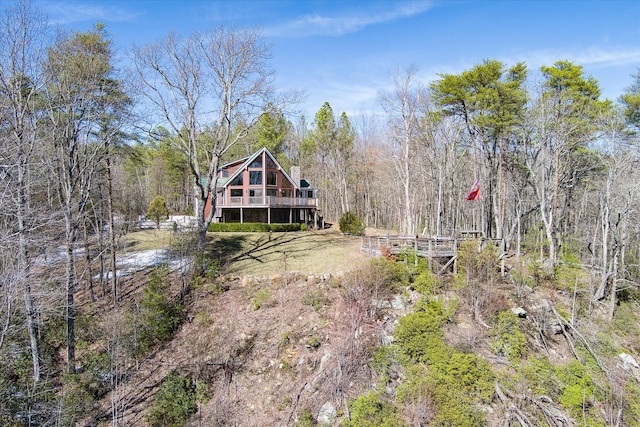 exterior space with a forest view and a wooden deck