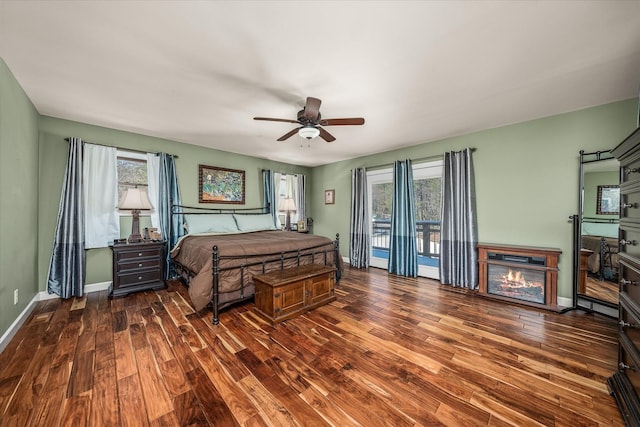 bedroom featuring access to exterior, multiple windows, and dark wood-style flooring