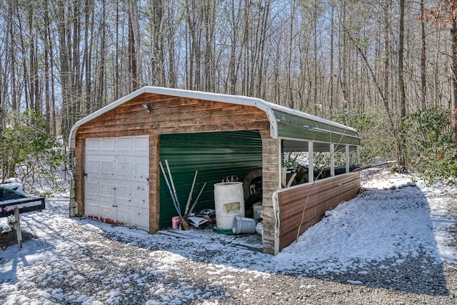 snow covered garage featuring a detached garage