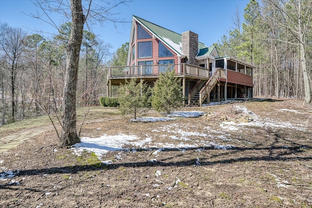 back of property with stairway, a chimney, and a deck