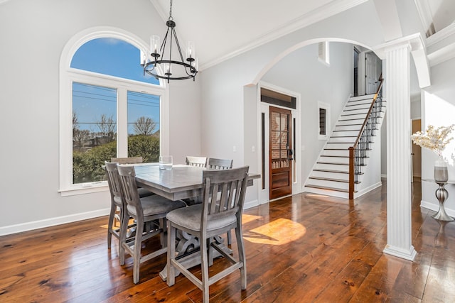 dining area with arched walkways, stairway, hardwood / wood-style flooring, and an inviting chandelier