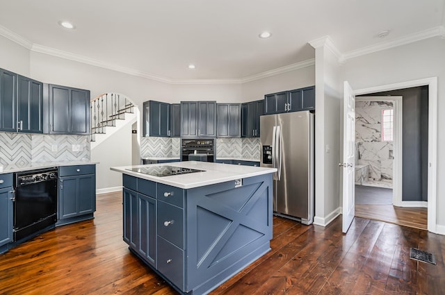 kitchen featuring black appliances, dark wood-style floors, light countertops, and ornamental molding