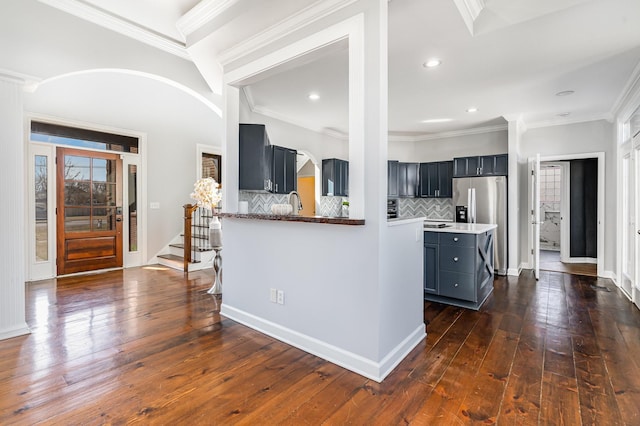 kitchen featuring dark wood-style floors, ornamental molding, backsplash, and dark cabinets