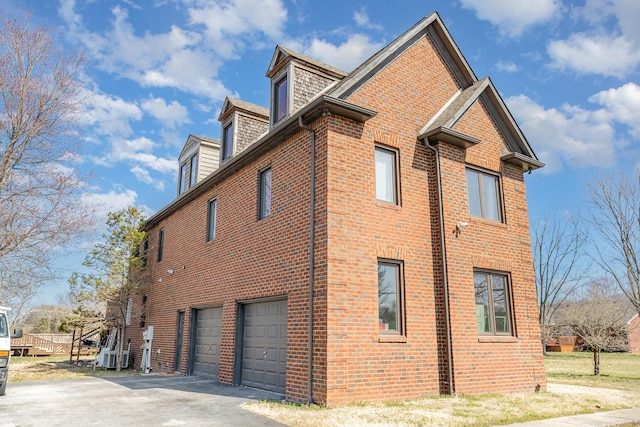 view of property exterior featuring aphalt driveway, brick siding, and an attached garage