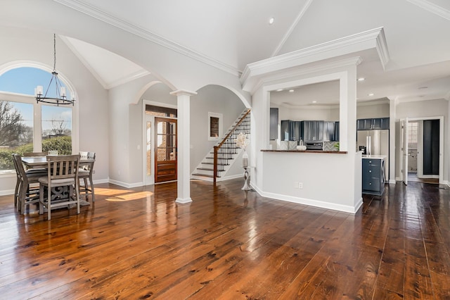 interior space with baseboards, dark wood-style floors, ornamental molding, stairs, and ornate columns