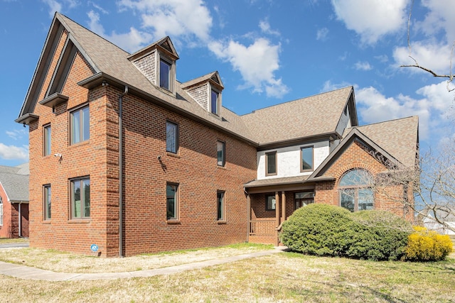 view of front of house featuring a shingled roof and brick siding