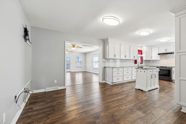 kitchen featuring a sink, a kitchen island, white cabinets, light countertops, and stainless steel range with electric stovetop