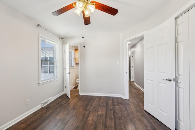 unfurnished bedroom with dark wood-style floors, baseboards, visible vents, and ceiling fan