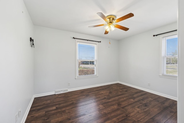 unfurnished room featuring a ceiling fan, dark wood-style flooring, visible vents, and baseboards