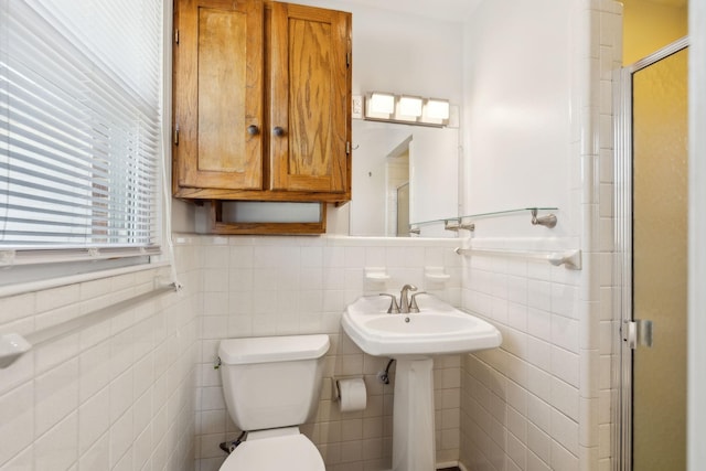 bathroom with tile walls, toilet, and an enclosed shower