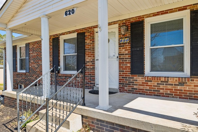 doorway to property featuring brick siding