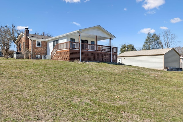 back of house featuring brick siding, a wooden deck, central AC unit, and a yard