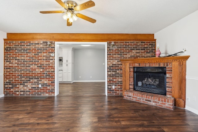 unfurnished living room featuring a fireplace, dark wood finished floors, a textured ceiling, and baseboards