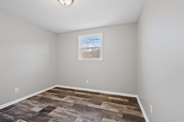 empty room featuring dark wood finished floors and baseboards