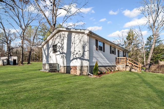 view of side of property with central AC and a lawn