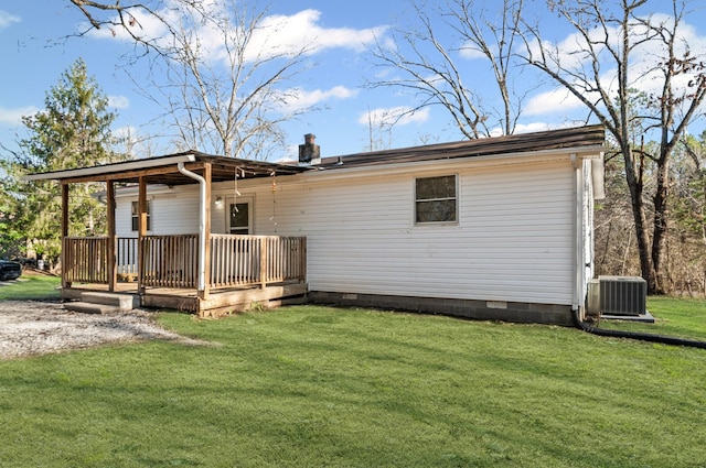 rear view of property featuring a deck, central air condition unit, crawl space, a lawn, and a chimney