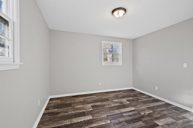 unfurnished room with dark wood-style floors and baseboards