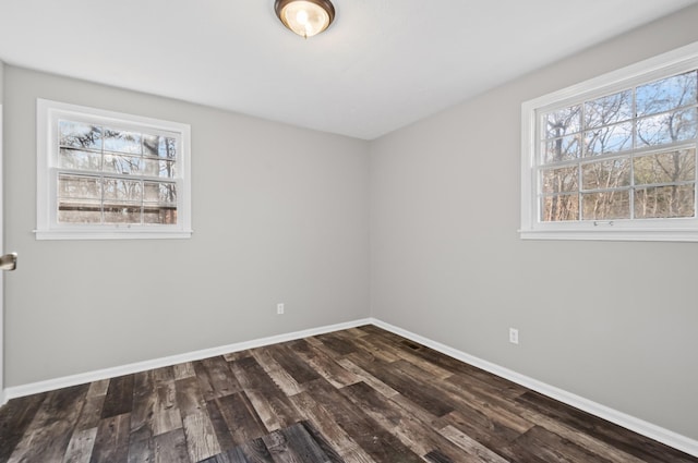 empty room with dark wood-style floors and baseboards