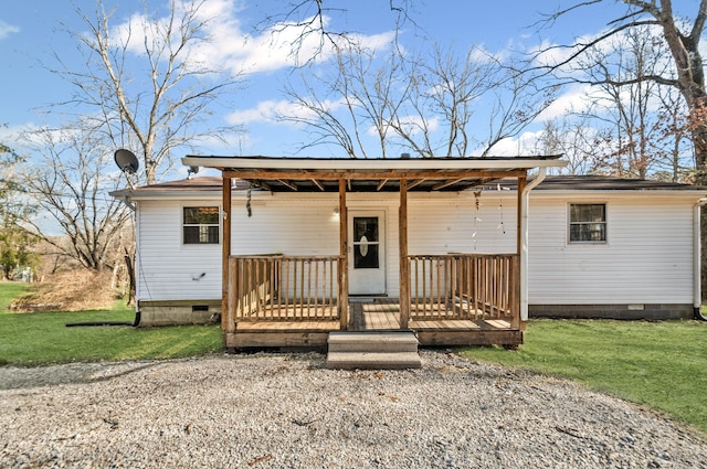 back of house with crawl space and a lawn