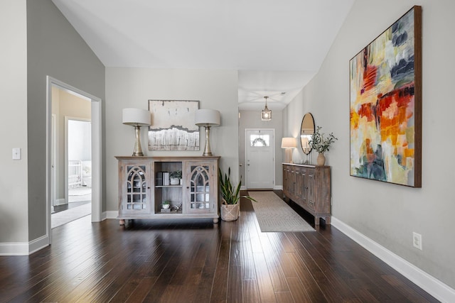 foyer entrance with dark wood-style floors and baseboards