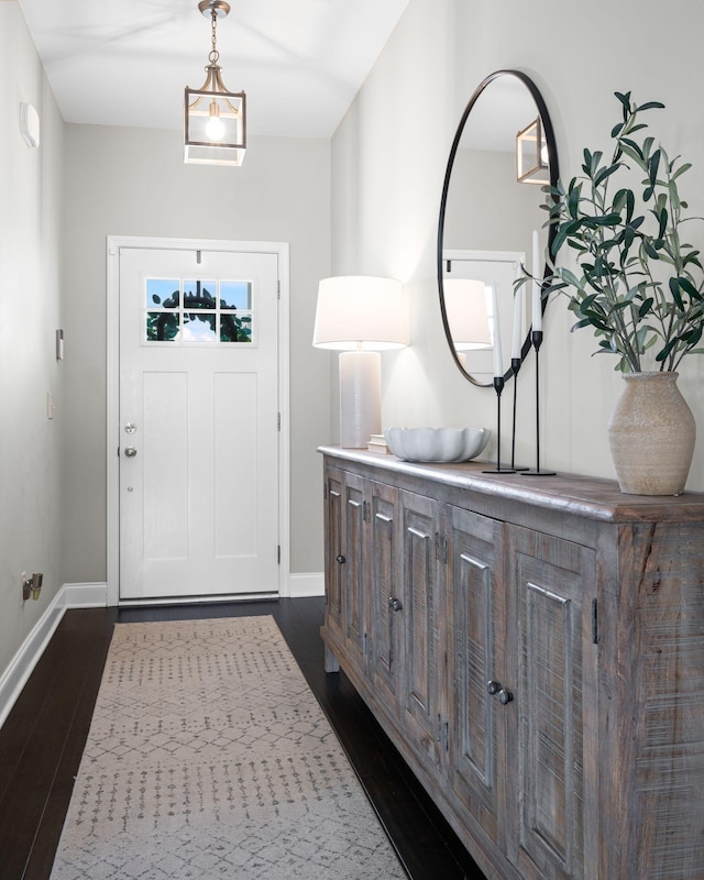 entrance foyer featuring dark wood finished floors and baseboards