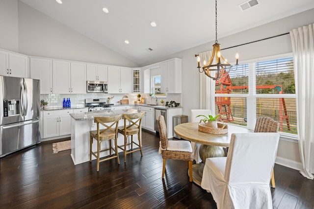 kitchen with white cabinets, visible vents, glass insert cabinets, and stainless steel appliances