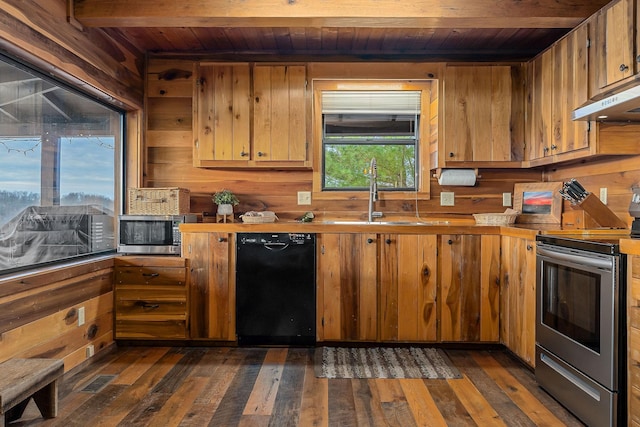 kitchen with stainless steel appliances, brown cabinetry, dark wood-type flooring, a sink, and under cabinet range hood