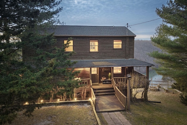 back of house featuring roof with shingles