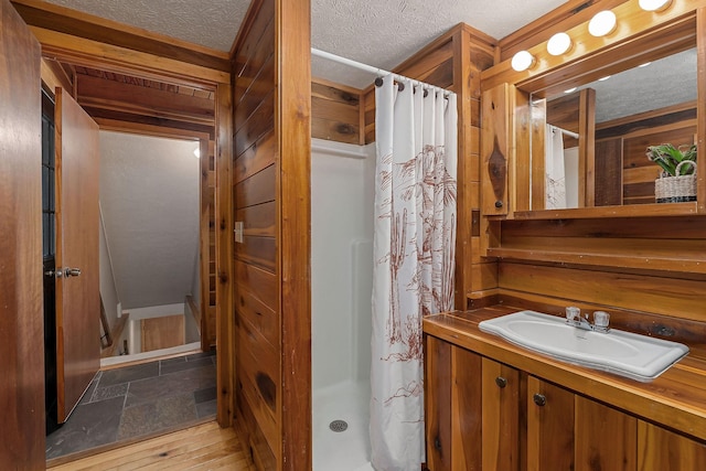 full bath with a textured ceiling and a stall shower