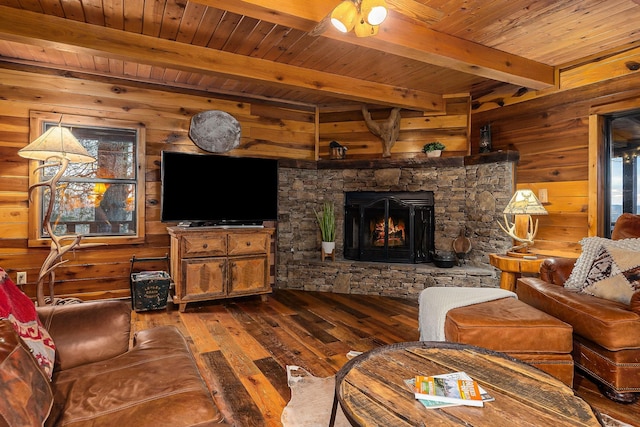 living area with dark wood finished floors, wooden walls, a fireplace, and beam ceiling