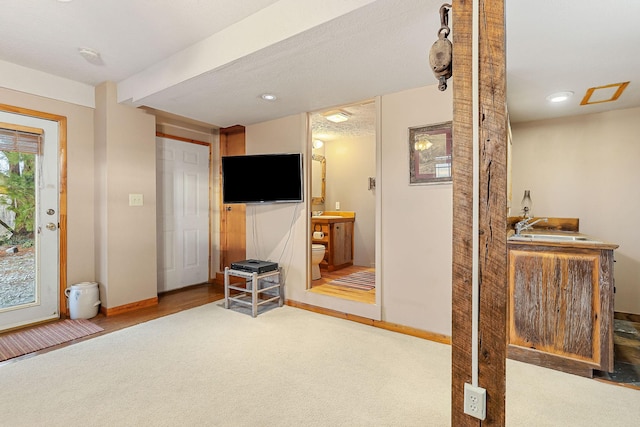 living area with baseboards and light colored carpet