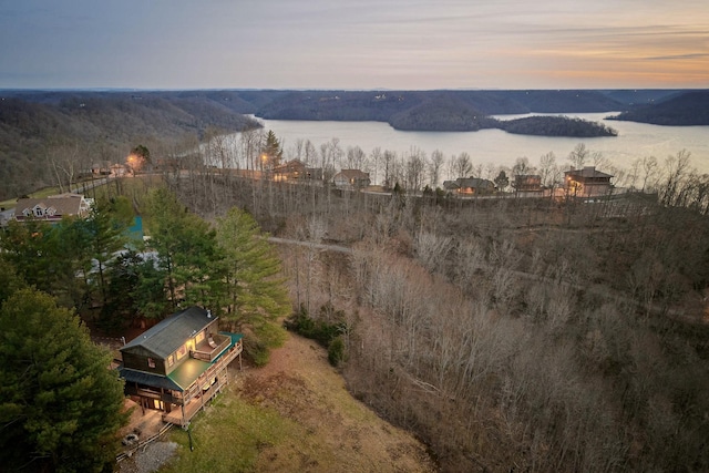 aerial view at dusk featuring a water view