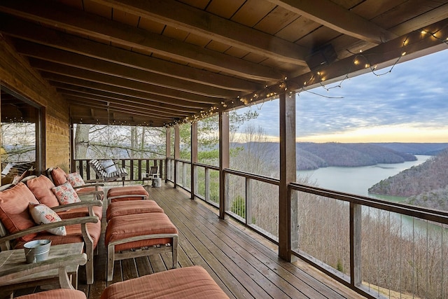 sunroom / solarium with a water view, wooden ceiling, and beam ceiling