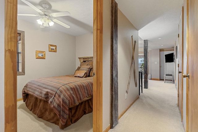 bedroom featuring light carpet, baseboards, and a ceiling fan