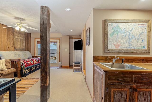 interior space with light carpet, baseboards, ceiling fan, a sink, and recessed lighting