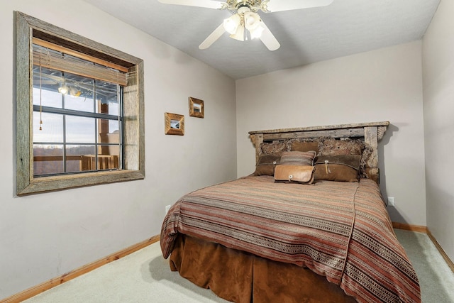 carpeted bedroom featuring a ceiling fan and baseboards