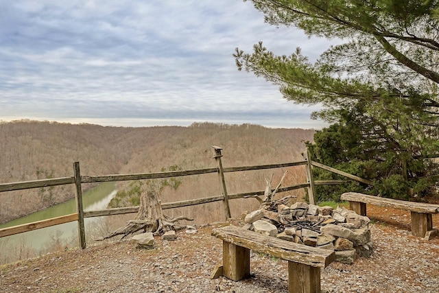 view of yard with fence, a wooded view, and a water and mountain view