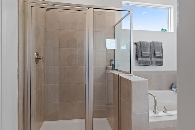 full bathroom featuring a shower stall and a bath