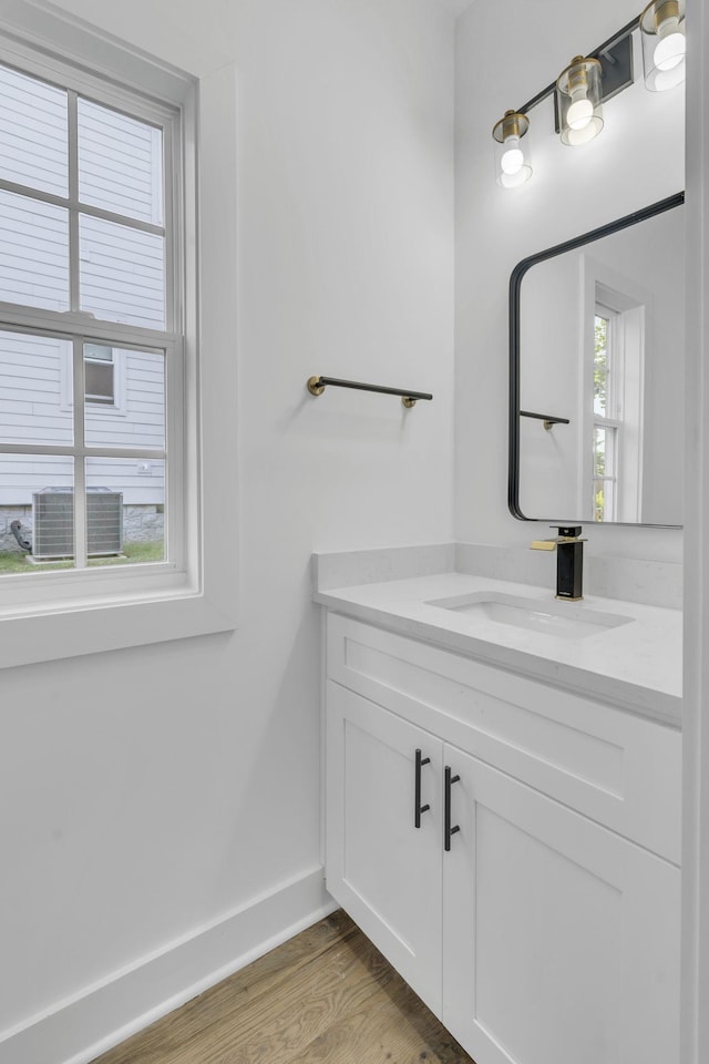 bathroom with vanity, baseboards, and wood finished floors