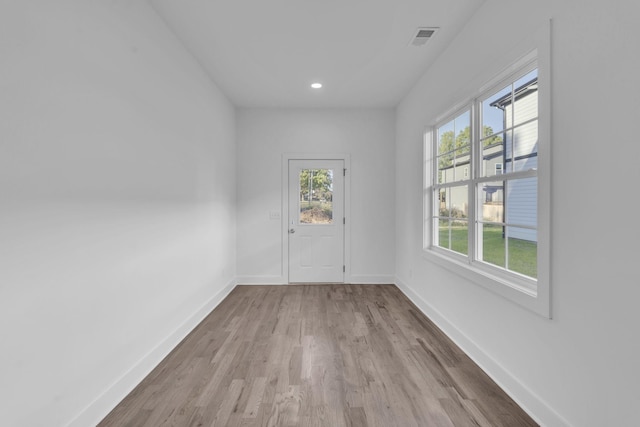 spare room with light wood-style flooring, recessed lighting, visible vents, and baseboards