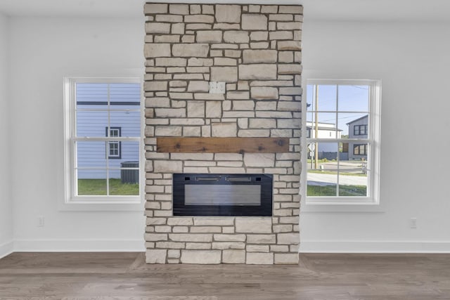 interior details with a fireplace, baseboards, and wood finished floors